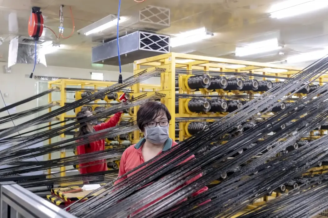 Công nhân kiểm tra sợi carbon nguyên chất tại dây chuyền sản xuất vật liệu tổng hợp của nhà máy Swancor Holding Co. ở Nam Đầu, Đài Loan. Hình ảnh: Lam Yik Fei/Bloomberg. 