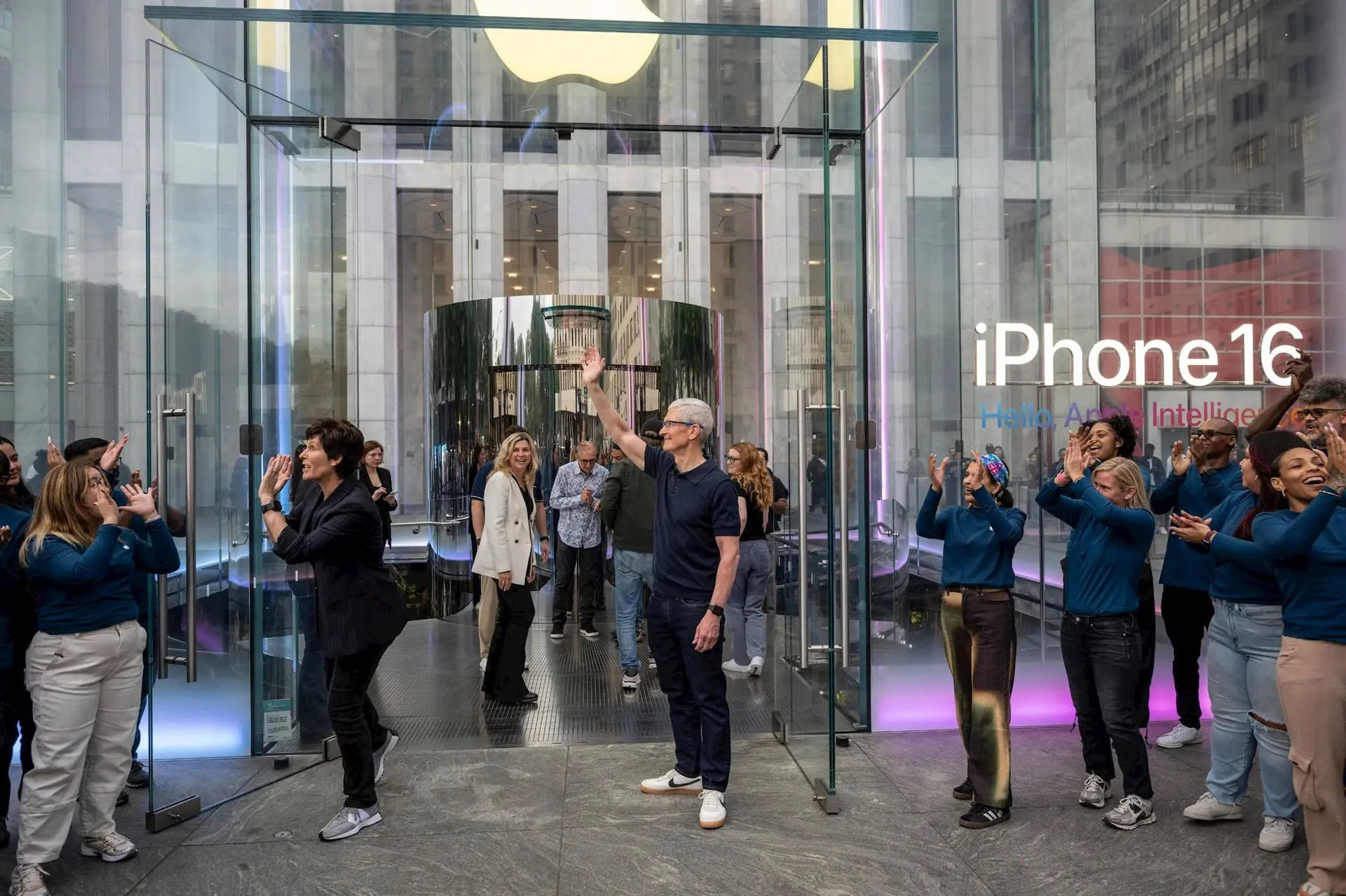 Tim Cook, giám đốc điều hành của Apple Inc., đứng giữa, chào đón khách hàng trong ngày đầu tiên mở bán các sản phẩm mới nhất của Apple tại cửa hàng Apple Fifth Avenue ở New York, Mỹ, vào thứ Sáu, ngày 20 tháng 9 năm 2024. Hình ảnh: Victor J. Blue/Bloomber 