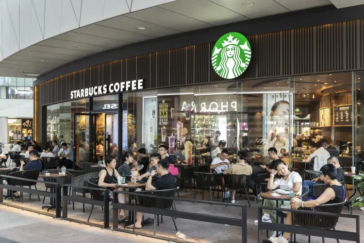 Khách hàng bên ngoài một cửa hàng cà phê Starbucks. Hình ảnh: Qilai Shen/Bloomberg