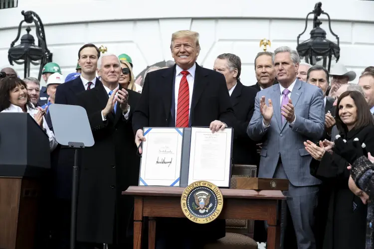 Tổng thống Donald Trump trưng bày Thỏa thuận Mỹ Mexico Canada đã ký vào năm 2020. Hình ảnh: Oliver Contreras/Sipa USA/Bloomberg