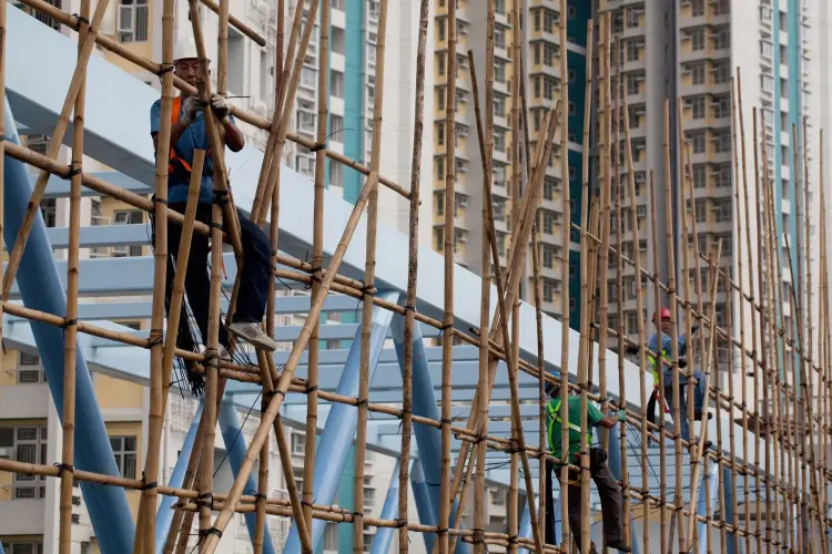 Công nhân dựng giàn giáo tre gần các tòa nhà chung cư tại vịnh Cửu Long. Hình ảnh: Daniel J. Groshong/Bloomberg.