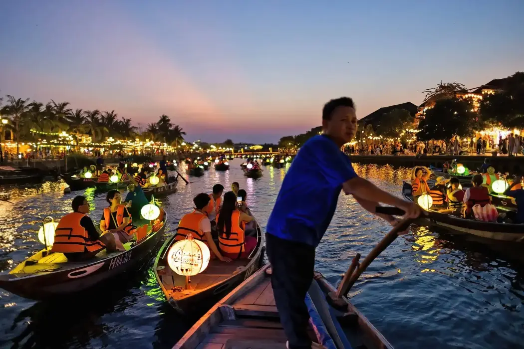 Du khách đi thuyền dọc theo dòng sông ở phố cổ Hội An. Hình ảnh: SeongJoon Cho/Bloomberg 