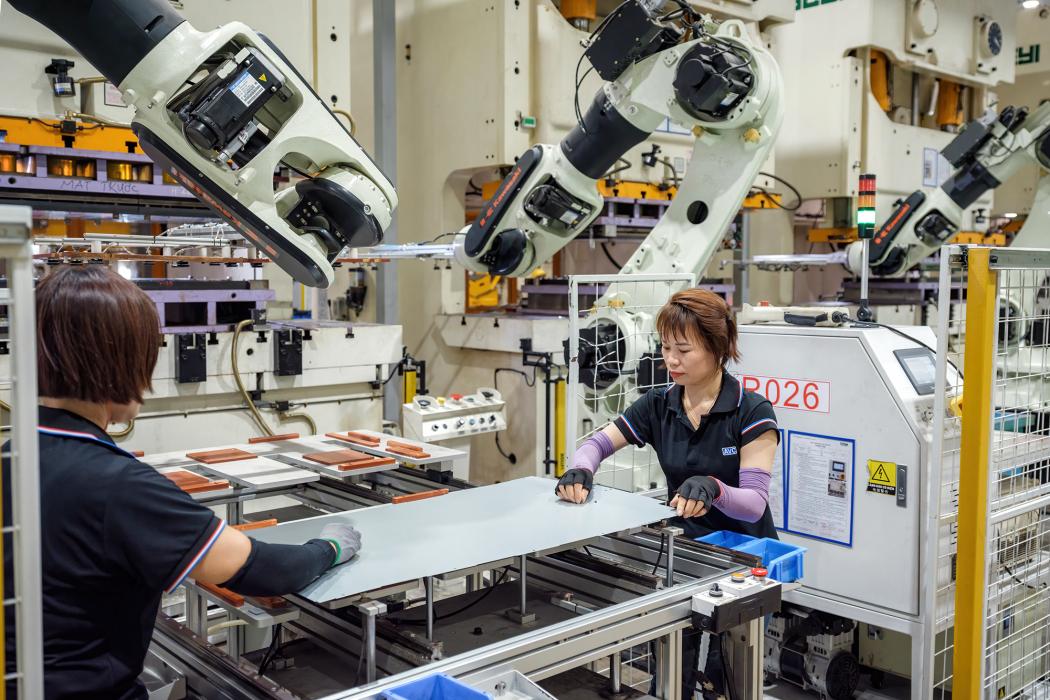 Công nhân kiểm tra khung máy chủ sau khi được robot sản xuất tại xưởng ép và dập của nhà máy Asia Vital Components Co. (AVC) ở xã Hoàng Đông, huyện Duy Tiên, tỉnh Hà Nam, Việt Nam. Hình ảnh: Linh Phạm/Bloomberg 