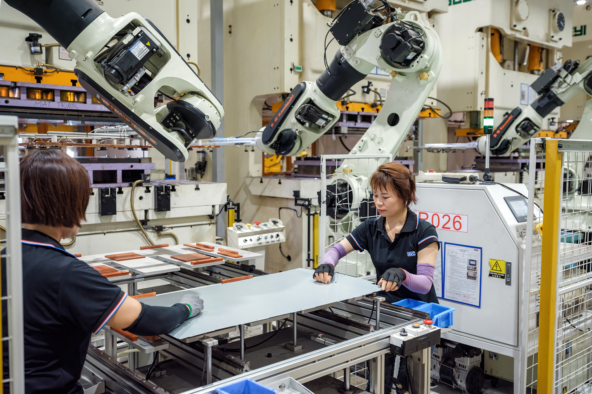 Công nhân kiểm tra khung máy chủ sau khi được robot sản xuất tại xưởng ép và dập của nhà máy Asia Vital Components Co. (AVC) ở xã Hoàng Đông, huyện Duy Tiên, tỉnh Hà Nam, Việt Nam. Hình ảnh: Linh Phạm/Bloomberg